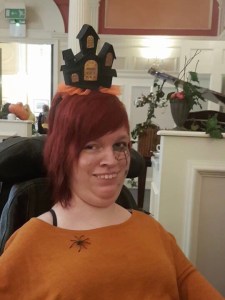 I am wearing orange and black. I have a plastic spider on my shoulder and a black and orange light up house style hat. 