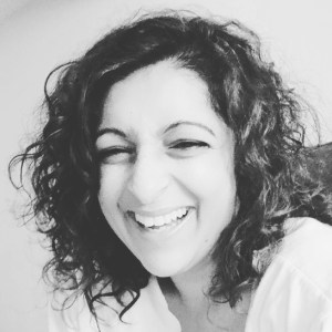 Portrait photo of Ritu smiling. In black and white. 