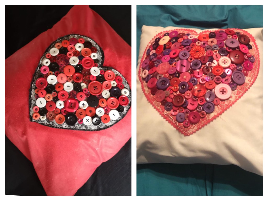 Two cushions decorated with lots of buttons sewn to form the shape of a heart. The are layered onto a large felt heard before being sewn on to the cushion. The cushion on the left is red black and white. The one on the right is pinks purples and reds. 
