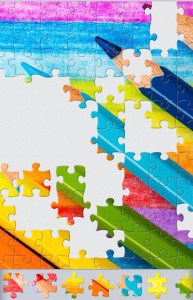 Another screenshot of a different puzzle. This jigsaw is of brightly coloured pencils. Some pieces are missing. There is a selection of jigsaw pieces at the bottom. 