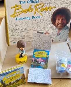 Bob Ross figure, paints and colouring book.